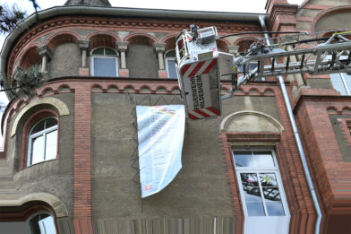 Das Lesezeichen an der Augustinus-Schule wird mit einem Leiterwagen angebracht.