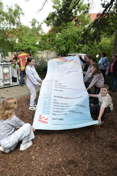 Kinder breiten das Lesezeichen-Banner aus.