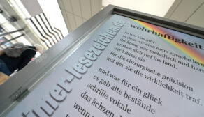 Das Lesezeichen mit dem Text "wehrhaftigkeit" hängt am Busbahnhof in Hildesheim.