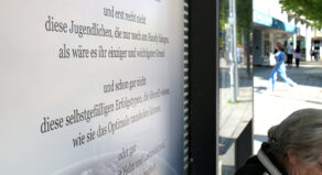 Lesezeichen an der Bushaltestelle am Huckup. Eine alte Frau sitzt an der Bushaltestelle.